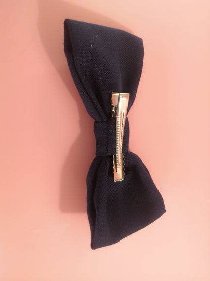 Dark blue bow with a flower vine pattern on one side and an ornament on the other